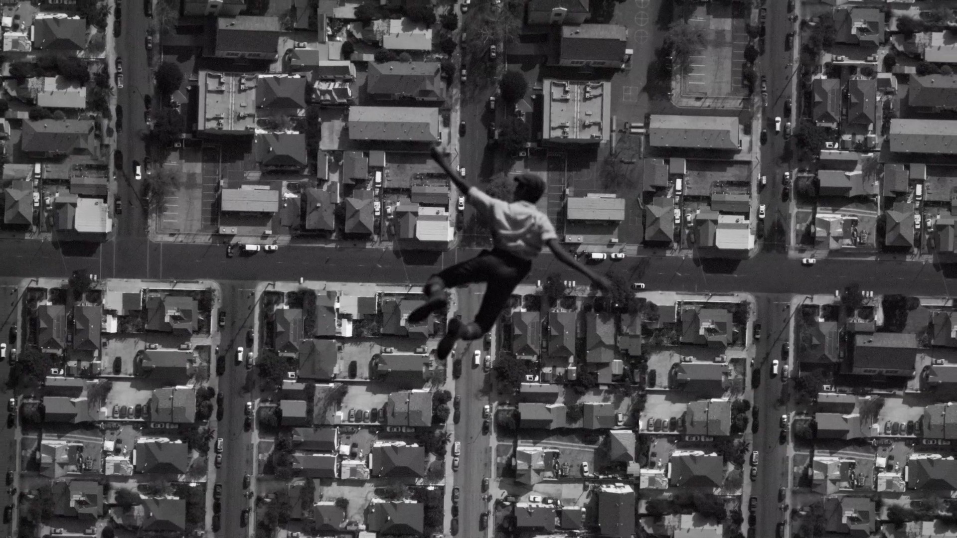 A film still from Kinloch showing a character falling into a neighboorhood